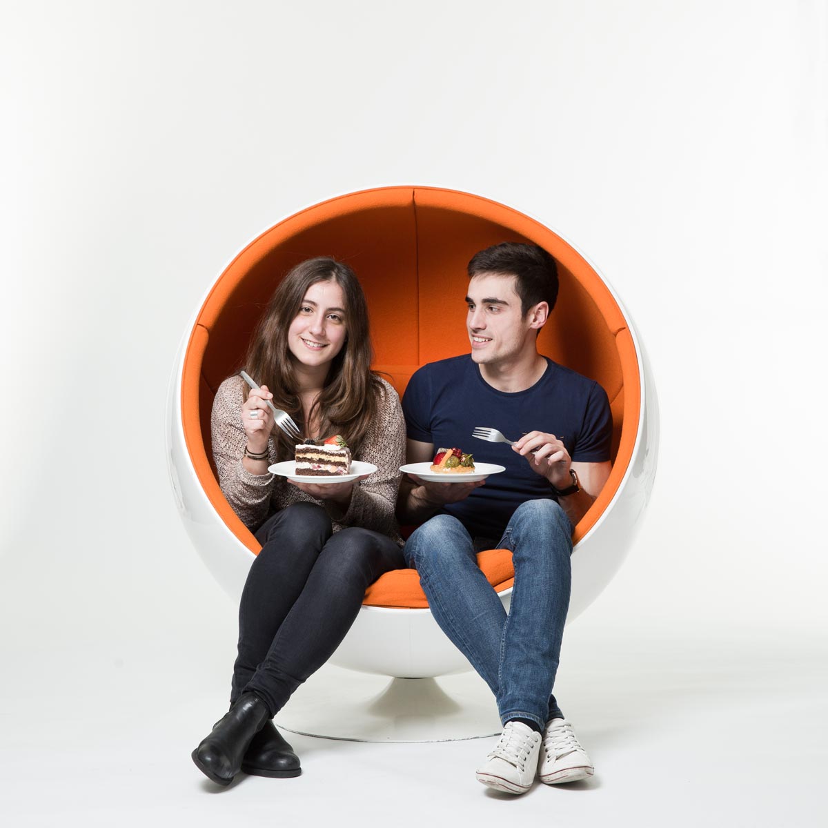 Two people sitting in orange chair